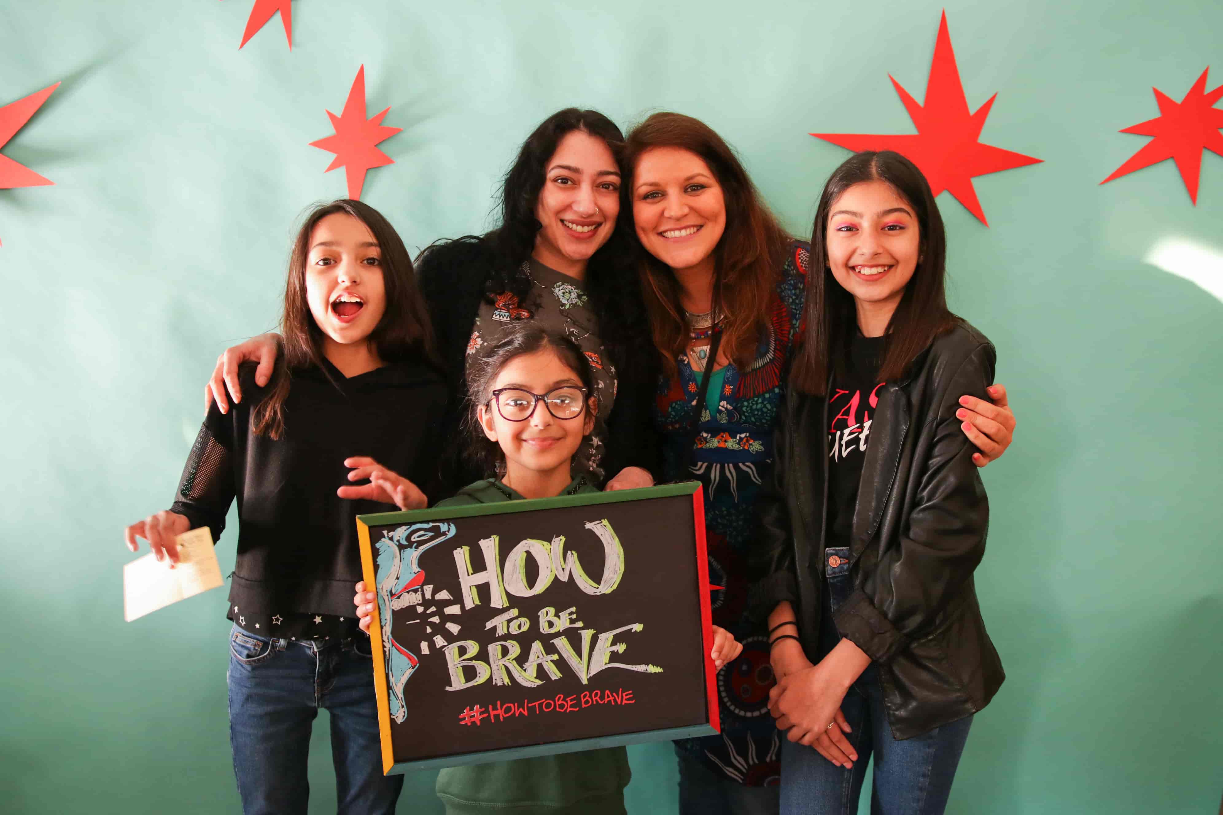 Image: People Smiling in  front of How To Be Brave Board Photo Credit: Fez