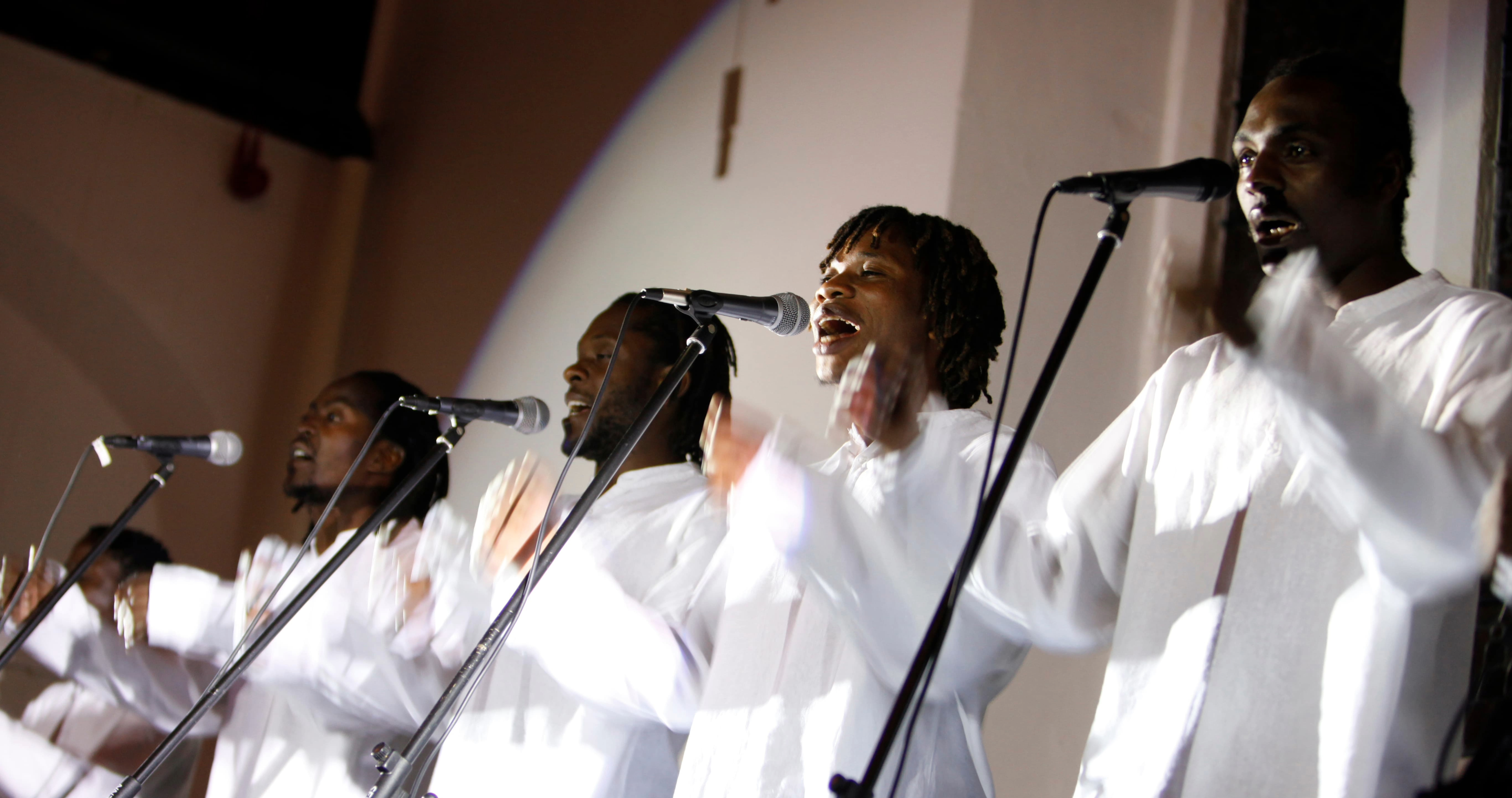 5 performers from Umdumo Wesizwe singing in a church hall. Image Credit Betina Skovbro