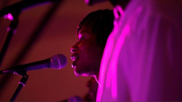 Image: Zimbawian singer from Umduno Wesizwe infront of microphone photo credit: Betina Skovbro